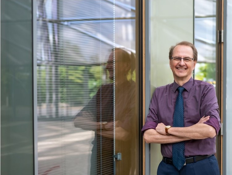 Dirk Messner, Leiter des Umweltbundesamtes lehnt sich an die Fenster des Umweltbundesamtes an
